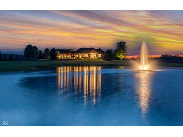 Stunning exterior view of a luxurious home reflecting beautifully in the tranquil pond at sunset at 2575 W 100 S, Franklin, IN 46131