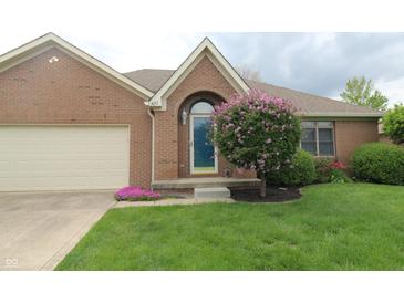 Charming brick home featuring a well-maintained lawn and colorful landscaping with an attached garage at 4652 Kensington N Way, Plainfield, IN 46168