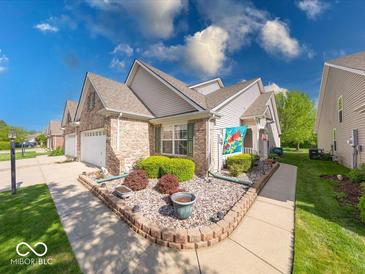 Charming townhome with a brick front, manicured lawn, and walkway to the front door at 6146 Franklin Villas Way, Indianapolis, IN 46237