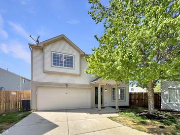 Charming two-story home with attached garage, landscaped front yard and beautiful mature tree on a sunny day at 6628 Dunsdin Dr, Plainfield, IN 46168