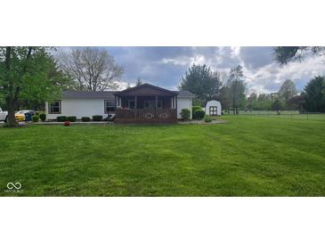 Charming home with a cozy front porch and lush green lawn at 7639 N Frontage Rd, Fairland, IN 46126