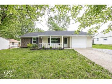 Charming one-story home with a well-manicured lawn and attached garage, complemented by a cozy front porch at 8145 Railroad Rd, Indianapolis, IN 46217