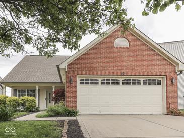 Charming single-story home featuring a red brick facade and a two-car garage with a well-manicured lawn at 820 Scotch Pine Dr, Greenwood, IN 46143