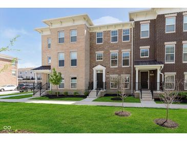 Attractive brick townhomes featuring well-maintained lawns, black railings, and contemporary architectural details at 13776 Tender Dr, Carmel, IN 46032