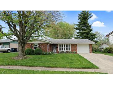 Charming single-story brick home featuring a well-manicured lawn and attached one-car garage at 1402 Arcola Ct, Beech Grove, IN 46107