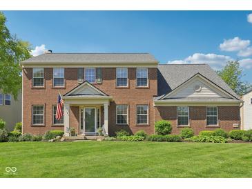 Charming two-story brick home featuring a well-manicured lawn and traditional architectural details at 14162 Nicholas Dr, Carmel, IN 46074