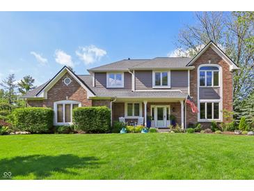 Beautiful two-story home with brick and siding, green lawn, and an inviting front porch with rocking chairs at 1508 Redwood Dr, Carmel, IN 46032