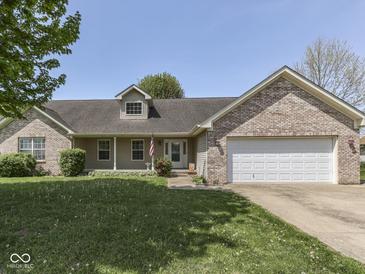 Inviting single-story home with a well-manicured lawn, brick accents, and an attached two-car garage at 1858 Jenny Dr, Martinsville, IN 46151