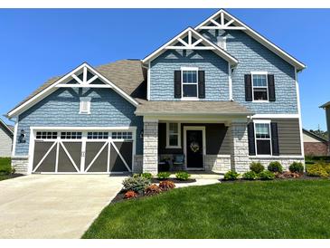 Charming two-story home featuring blue siding, stone accents, a well-manicured lawn, and an attached two-car garage at 2075 Longford Ln, Avon, IN 46123