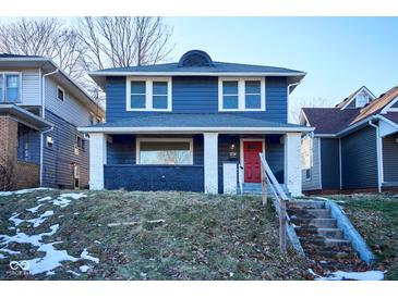 Charming two-story home featuring a bright red front door, blue siding and a welcoming front porch at 2714 N Capitol Ave, Indianapolis, IN 46208
