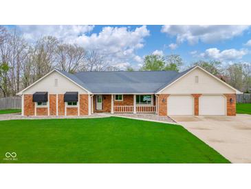 Charming brick home with well-maintained lawn, two-car garage and welcoming front porch at 310 Edgewood E Pl, Anderson, IN 46011