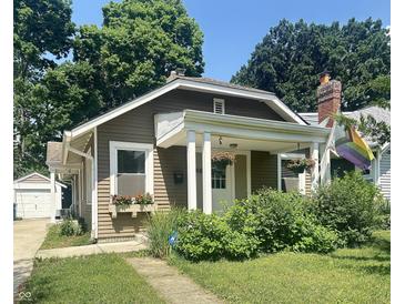 Charming single-story home with a cozy front porch and well-maintained landscaping in a residential neighborhood at 4406 Carrollton Ave, Indianapolis, IN 46205