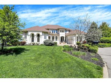 A light-colored two-story home surrounded by a lush green lawn, showcasing classic architecture and landscaping at 4726 Ellery Ln, Indianapolis, IN 46250