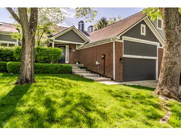 Charming brick home with an attached garage and meticulously landscaped front yard at 7849 Clearwater Cove Dr, Indianapolis, IN 46240