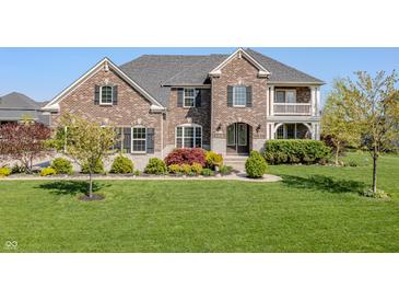 Beautiful two-story brick home with a manicured lawn and lovely landscaping at 10473 Ranford Blvd, Fishers, IN 46040