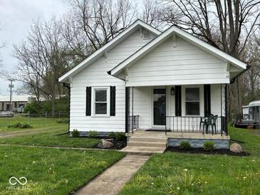 Charming home with a welcoming front porch, black shutters, and a well-manicured lawn at 1405 S Ribble Ave, Muncie, IN 47302