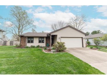 Charming home with a well-manicured lawn and an attached two-car garage at 3003 Foxpointe Dr, Columbus, IN 47203