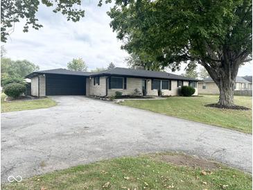 Charming single-story home features a spacious yard, attached garage, and lovely landscaping at 6811 S Meridian St, Indianapolis, IN 46217