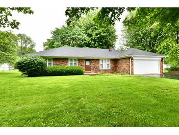 Charming brick ranch home with an attached garage and lush green lawn at 12087 N Gasburg Rd, Mooresville, IN 46158