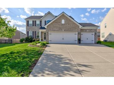 Charming two-story brick home featuring a three car garage, landscaped yard, and welcoming curb appeal at 1662 Cascade Dr, Greenwood, IN 46143