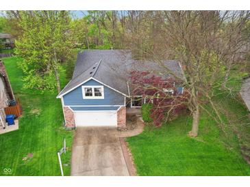 Aerial view of a beautiful blue house with a well-maintained lawn and mature trees at 524 Deerberry Dr, Noblesville, IN 46062