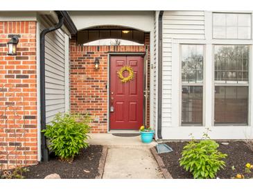 Charming red front door with decorative wreath and brick accents at 6140 King Lear Ln, Indianapolis, IN 46254
