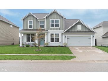 Charming two-story home featuring a well-manicured lawn, attached two-car garage, and a welcoming covered front porch at 6164 Brighton Dr, Whitestown, IN 46075