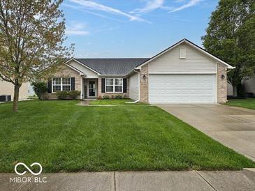 Charming single-story home features a well-maintained lawn and a two-car garage at 7108 Burlat Ln, Noblesville, IN 46062