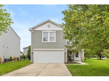 Charming home featuring gray siding, a two-car garage, and a well-manicured front yard with a walkway to the front door at 9307 W Dockside Cir, Pendleton, IN 46064