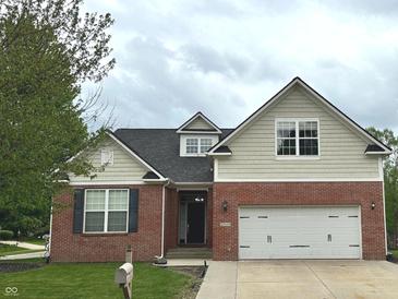 Charming two-story home featuring a brick facade, two car garage and a well-manicured lawn at 18680 Long Walk Ln, Noblesville, IN 46060