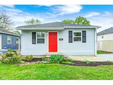 Charming single-story home with a bright red door, tidy landscaping, and neutral siding at 2021 Reformers Ave, Indianapolis, IN 46203