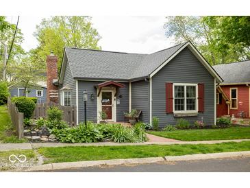 Charming bungalow with gray siding, brick chimney, well-manicured landscaping, and mature trees at 440 Linden St, Zionsville, IN 46077