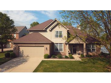 Charming two-story home with a well-manicured lawn, attached garage, and inviting front entrance at 6360 E Chapel Hill Ct, Camby, IN 46113