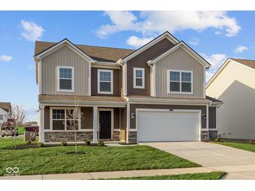Two-story home featuring a white garage door, brown siding and coordinated stonework on the facade at 7417 Waylon Way, Indianapolis, IN 46239