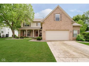 Charming two-story home with brick and vinyl siding, manicured lawn, and covered front porch at 11141 Saybrook Ct, Fishers, IN 46037