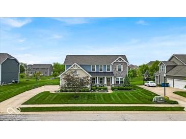 Beautiful two-story home with manicured lawn, stone accents and covered entry at 11438 Montoya Dr, Zionsville, IN 46077