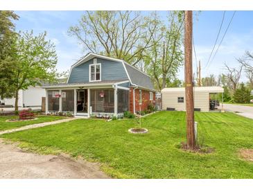 Charming home featuring a screened-in porch, well-maintained lawn, and convenient detached garage for parking at 116 High St, Brooklyn, IN 46111