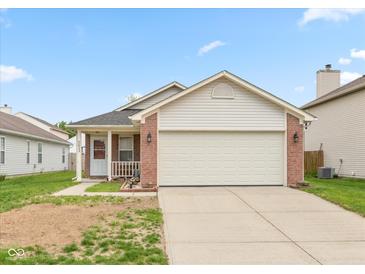 Charming single Gathering home with a brick facade, attached two-car garage and manicured lawn at 2623 Santaro Ct, Indianapolis, IN 46217