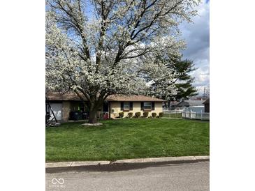 Charming single-story home with lush green lawn, flowering tree, and well-manicured landscaping at 5218 Fletcher St, Anderson, IN 46013