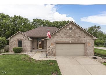 Charming brick home featuring an attached garage, well-manicured lawn, and a welcoming front entrance at 5499 Steven Dr, Greenwood, IN 46142