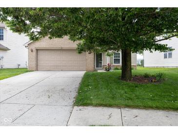 Charming home featuring a two-car garage, brick accents, and a well-maintained lawn at 6516 Amherst Way, Zionsville, IN 46077