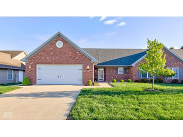 Charming brick home featuring an attached two-car garage and a well-manicured lawn at 710 Monarch Ln, Lebanon, IN 46052