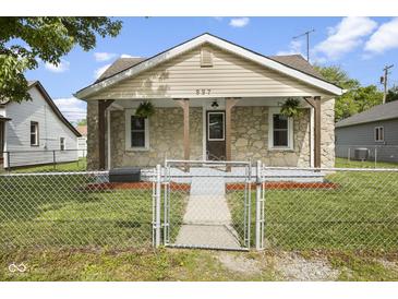 Charming stone-clad home featuring a cozy front porch with wood supports and manicured lawn at 997 Yandes St, Franklin, IN 46131