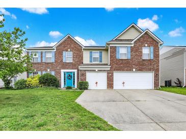 Charming two-story brick home with a well-manicured lawn, two-car garage, and a vibrant blue front door at 10828 Young Lake Dr, Indianapolis, IN 46229