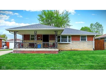 Charming single-story brick home featuring a cozy front porch and well-maintained lawn at 1964 Mann Dr, Beech Grove, IN 46107