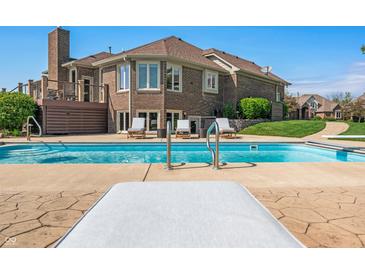 Inviting backyard pool with lounge chairs, decking, and view of the home's brick exterior at 2015 Saint Andrews Ct, Franklin, IN 46131