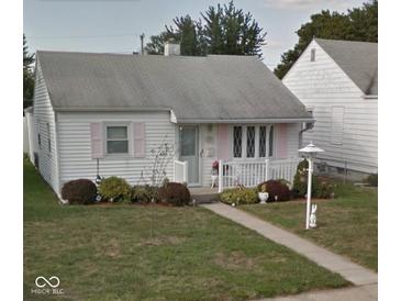 Charming single story home with white siding, walkway and pretty landscaping at 318 Elva St, Anderson, IN 46013