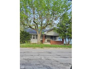 Charming single-story home with a brick porch and mature trees adding character to the property at 3547 N Emerson Ave, Indianapolis, IN 46218