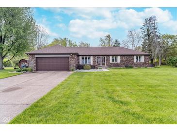 Charming brick ranch home with a well-manicured lawn and attached two-car garage at 417 W Ash St, Jamestown, IN 46147