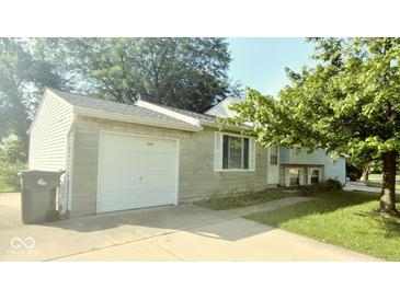 Charming home featuring an attached garage, well-manicured lawn, and inviting front porch at 5415 Wagon Wheel Trl, Indianapolis, IN 46237